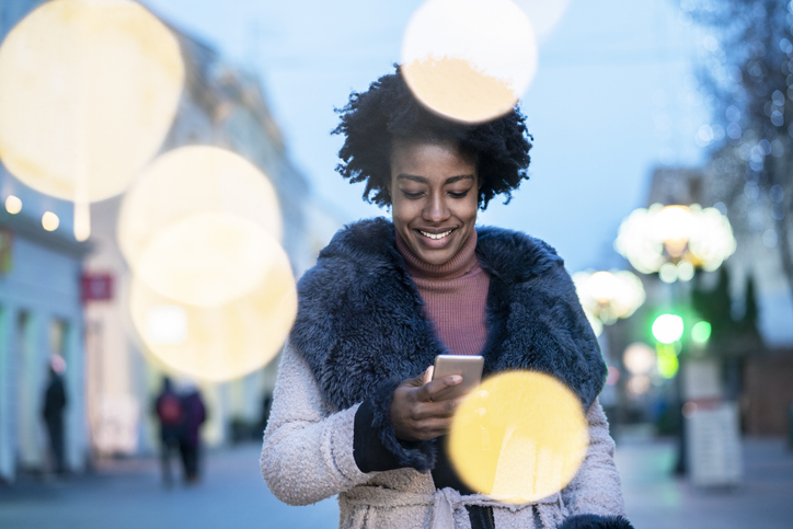 Young woman using smart phone at the street