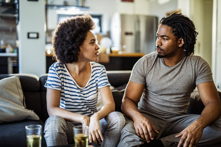 Young African American couple talking in the living room.