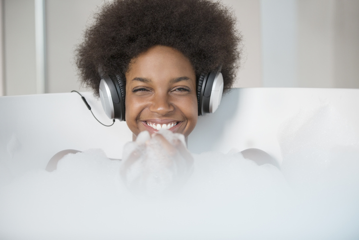 Woman listening to headphones in bath