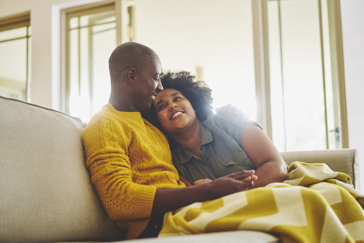 Affectionate couple relaxing on their living room sofa together