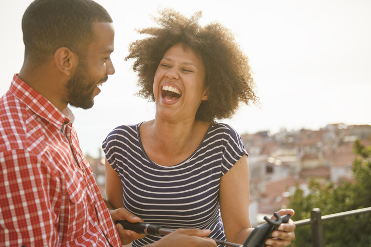 Young afro american couple having fun with selfie stick