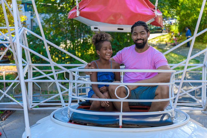 An African-American Family is Enjoying on Ferris Wheel in Amusement Park.