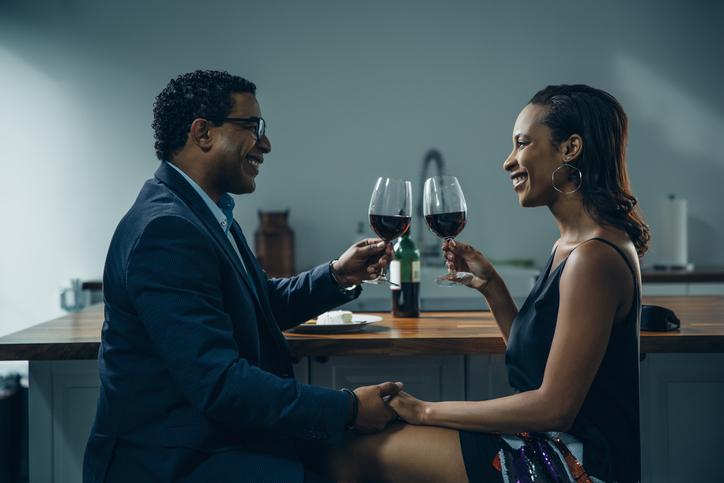 Couple toasting with wine at counter