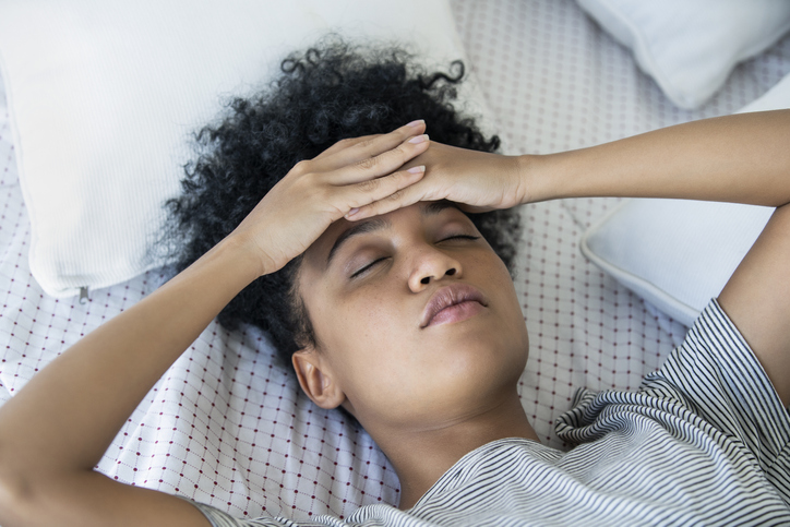 Close-up of young woman suffering from headache