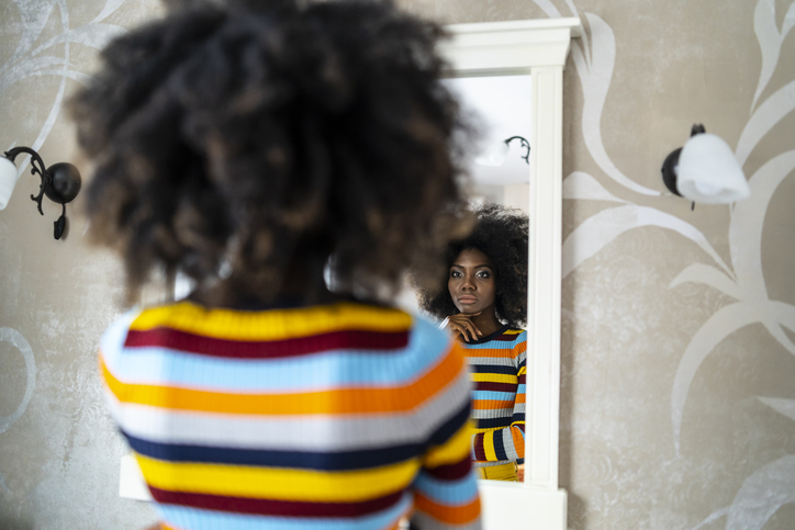 Woman looking at her reflection in the mirror