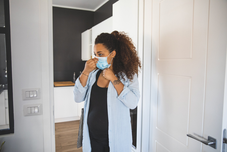 Woman preparing to go out wearing a surgical mask