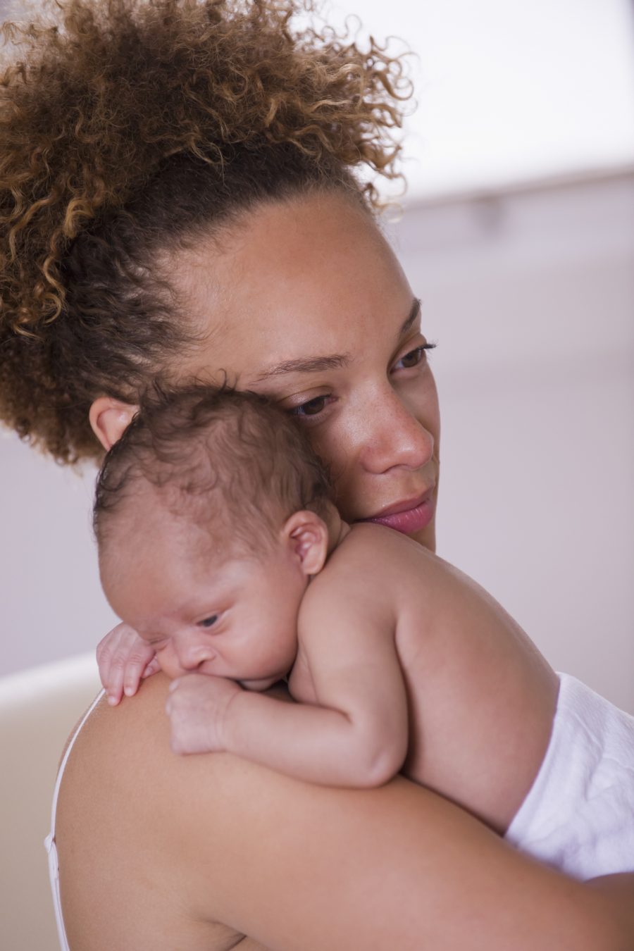 African American woman holding newborn baby