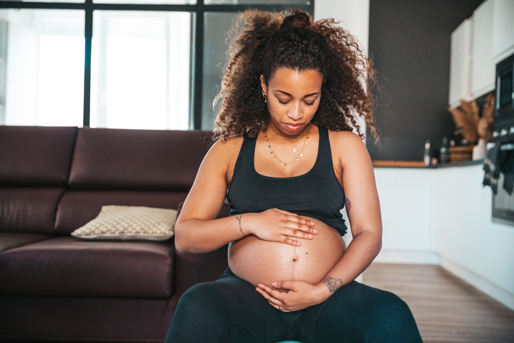 Pregnant woman having a work video call with colleagues