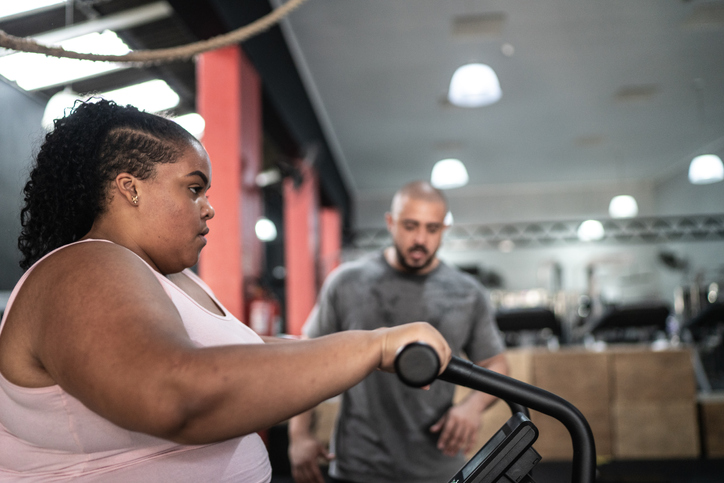 Side view of a young woman exercising in the gym