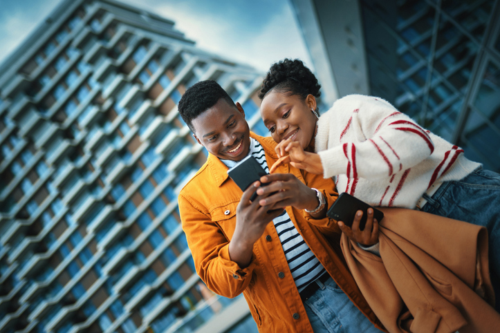 Young Afro American couple enjoying sunny day and taking selfies.