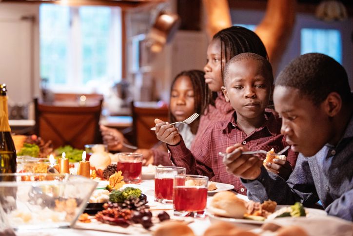 American-African family at table during thanksgiving dinner