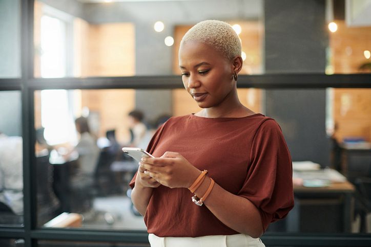 Shot of a young businesswoman using a smartphone in a modern office